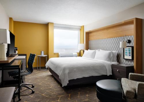 a hotel room with a bed and a desk at Holiday Inn Boston - Dedham Hotel & Conference Center by IHG in Dedham