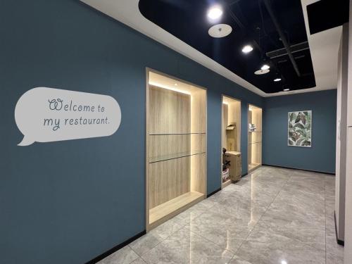 a hallway with a door with a sign that says welcome to my restaurant at Benz Hotel in Zhongli
