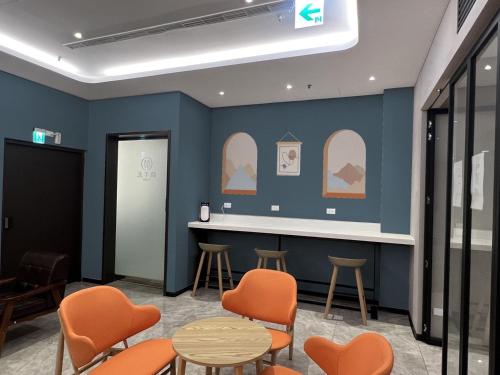 a waiting room with orange chairs and a counter at Benz Hotel in Zhongli