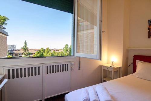 een slaapkamer met een bed en een groot raam bij BidiBo apartment, in centro comodo alla Stazione in Bologna