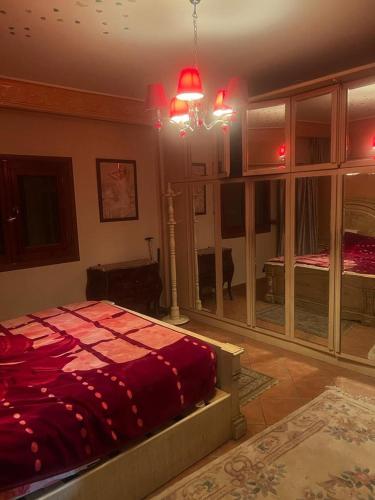 a bedroom with a large bed with a red blanket at Style home in Cairo
