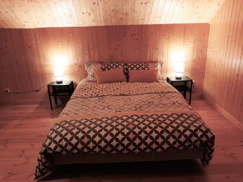 - une chambre avec un lit et 2 lampes sur 2 tables dans l'établissement Le chalet de Pierrot, à La Malène