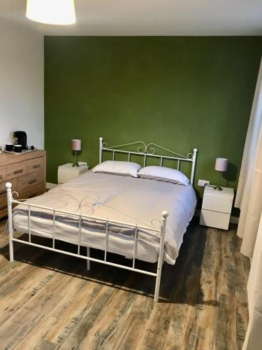 sypialnia z białym łóżkiem i zieloną ścianą w obiekcie 27 William Jessop Way Bristol BS13 0RL w mieście Whitchurch