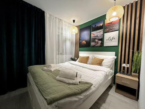 a bedroom with a large white bed with green walls at Rein Old Town in Sibiu