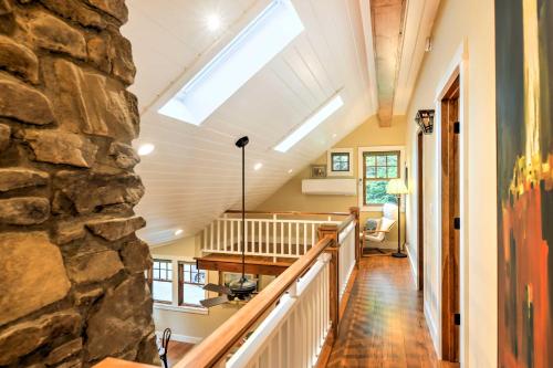 a room with a stone wall and a skylight at Sugar Berry-Remodeled Laughlintown Craftsman Home! in Laughlintown