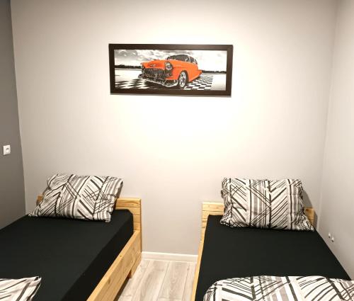 a room with two beds and a picture of a truck on the wall at WRN APARTAMENTY in Kalisz