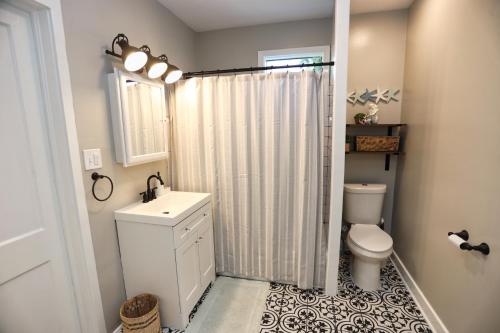 y baño con aseo, lavabo y ducha. en Adorable 2-bedroom guest house with free parking, en Galveston