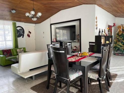 a dining room with a table and chairs and a couch at CASA CAMPESTRE VILLA JULIA in Quetame