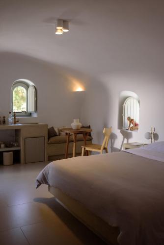a bedroom with a bed and a living room at Oia Treasures Art Suites in Oia