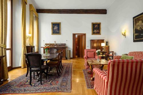 uma sala de estar com mesa e cadeiras em Piazza DUOMO - Antico Appartamento dell'800 em Milão