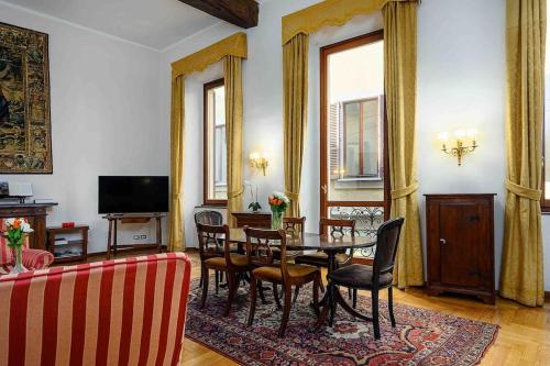 a living room with a dining room table and chairs at Piazza DUOMO - Antico Appartamento dell'800 in Milan