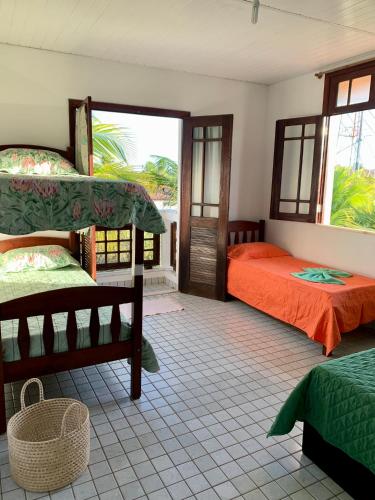 a bedroom with two beds and a window at Casa com piscina no Maçarico - Casa Água Viva in Salinópolis