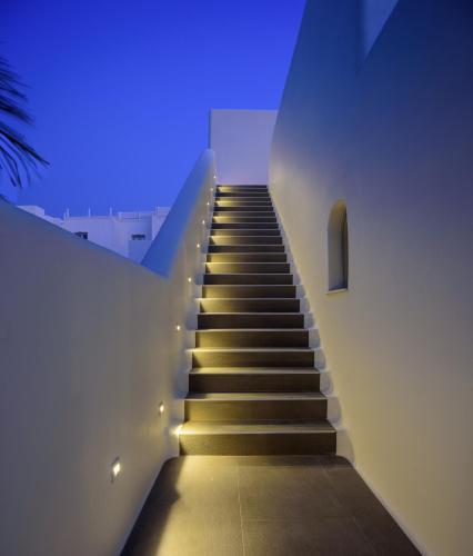a staircase leading up to a building with blue lights at Oia Treasures Art Suites in Oia