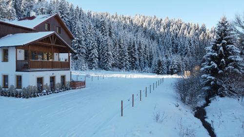 a house in the snow with a fence at Apartmán Hugo Blatná in Horní Blatná