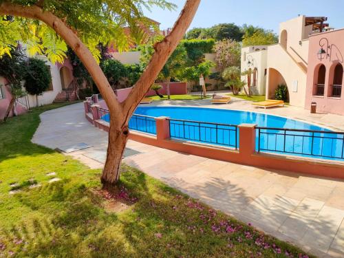 a swimming pool in a yard next to a house at Nice tow bedrooms by snake pool in talapay in Aqaba