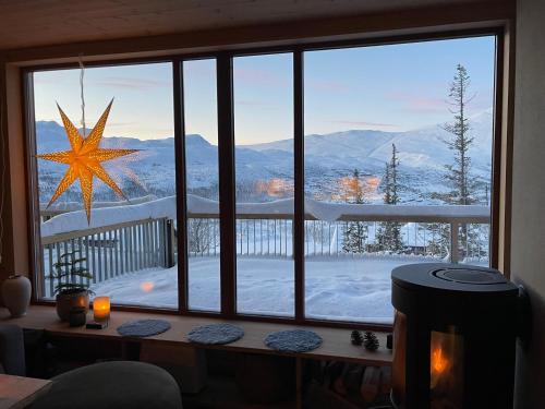 una ventana con vistas a una montaña nevada en Astonishing Mountain Lodge at the top of Gaustablikk, 25m2 west facing terrace, 3 bedrooms, en Gaustablikk