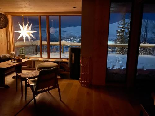 a living room with a view of a snow covered mountain at Astonishing Mountain Lodge at the top of Gaustablikk, 25m2 west facing terrace, 3 bedrooms in Gaustablikk