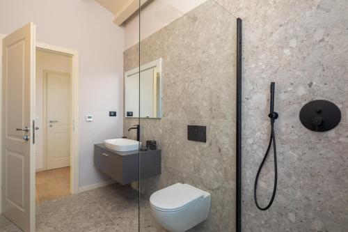 La salle de bains est pourvue de toilettes et d'une douche en verre. dans l'établissement Villa Iris by ILC (Istria Luxury Collection), à Brtonigla