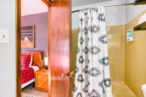 een badkamer met een douchegordijn en een slaapkamer bij Mountain Rider - Unit A in Red River