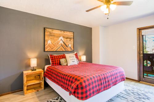 1 dormitorio con 1 cama con manta roja a cuadros en Mountain Rider - Unit A en Red River