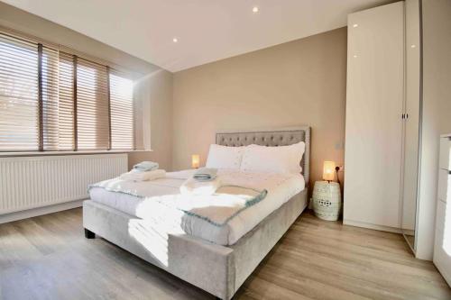 a bedroom with a large bed and a window at Luxury London Garden Flat in London