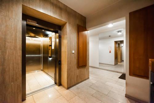 korytarzem z windą w budynku w obiekcie EKO PARK Abdank White Apartment w Warszawie