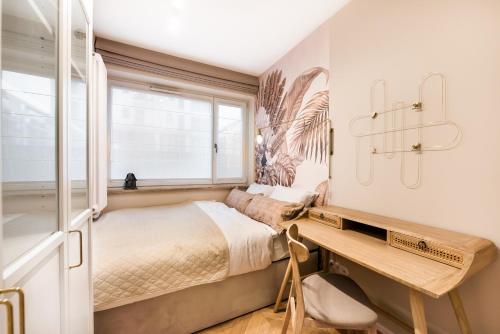 a bedroom with a bed and a desk and a window at EKO PARK Abdank White Apartment in Warsaw