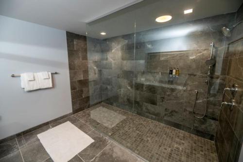 La salle de bains est pourvue d'une douche avec une porte en verre. dans l'établissement Oaks on the River, à Darien