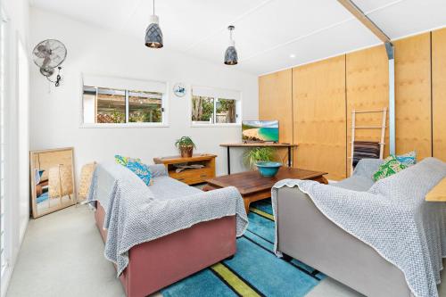 a living room with two chairs and a table at Sojourne - Perfect for 2 Families in Shoalhaven Heads