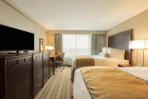 a hotel room with two beds and a flat screen tv at Country Inn & Suites by Radisson, Bemidji, MN in Bemidji