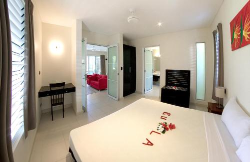 a bedroom with a bed and a living room at First Landing Beach Resort & Villas in Lautoka