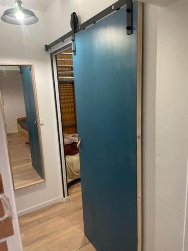 - une porte bleue dans une pièce avec un miroir dans l'établissement Pra-loup 1600, à Uvernet