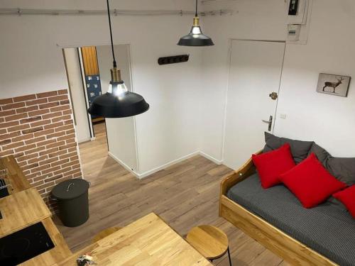 a living room with a bed with red pillows at Pra-loup 1600 in Uvernet-Fours
