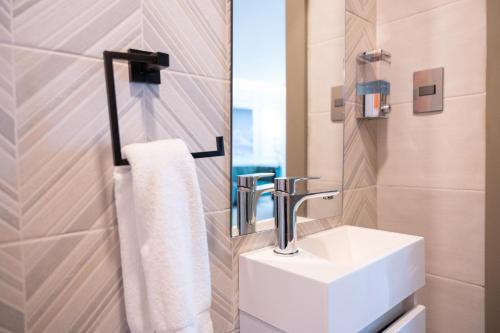 Un baño con un lavabo blanco y un espejo. en Top Floor in Luxury Tower, en Santiago de los Caballeros