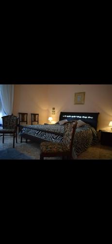 シラクーサにあるAl Mazari homeのベッドルーム1室(ベッド2台、シマウマのプリントのソファ付)