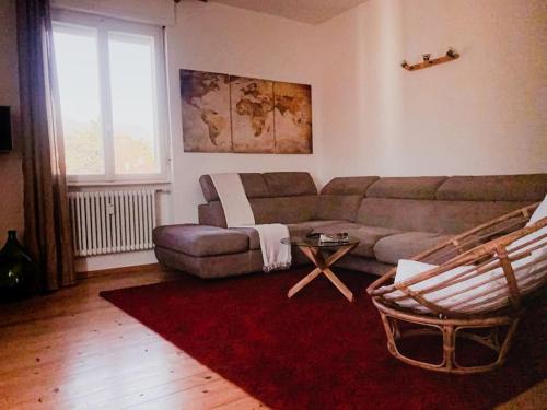 un soggiorno con divano e tappeto rosso di Il VagaMondo a Rovereto