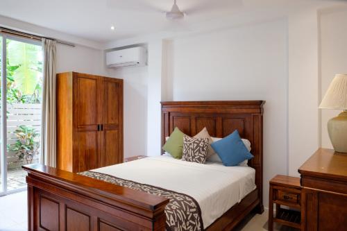 a bedroom with a bed with a wooden headboard at First Landing Beach Resort & Villas in Lautoka