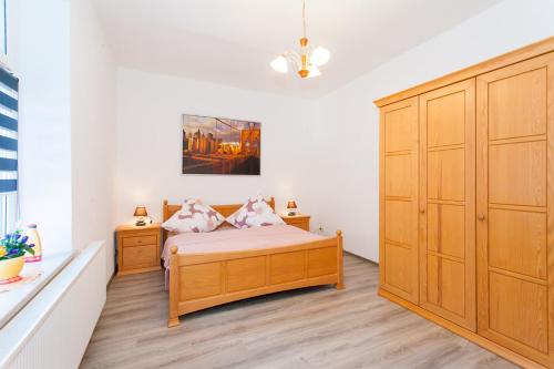 a bedroom with a bed and a large wooden cabinet at Apartment Zoey in Auerbach