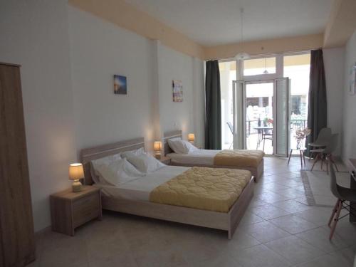 a bedroom with two beds and a balcony at Katerina Apartments near the Sea in Zakynthos Town