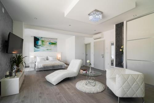 a white living room with a bed and a table at Villa Palladium in Makarska