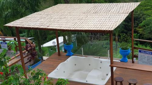 a wooden deck with a gazebo with a sink at Vila Lia in São Sebastião