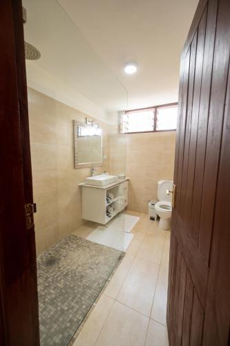 a bathroom with a sink and a toilet at Oasys House - Beautiful Private Beach Front Home in Msambweni