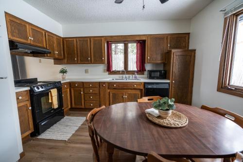 een keuken met houten kasten en een houten tafel bij Cuyuna Lakes Stay in Deerwood