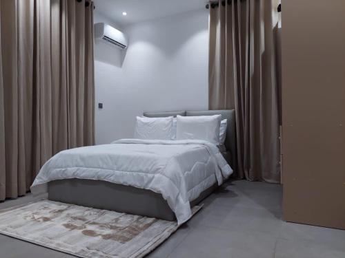 a bedroom with a bed with white sheets and pillows at Harbor Pond Apartments 2 in Lagos