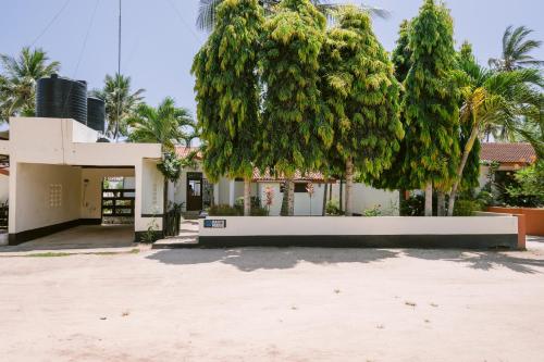 a building with a tree in front of it at Oasys House - Beautiful Private Beach Front Home in Msambweni