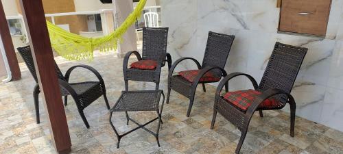 four black chairs with red seats on a patio at Apartamento de Cobertura frente para o mar Itapema in Itapema