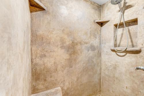a bathroom with a shower with a stone wall at Wildcat Family Ranch in Murphys
