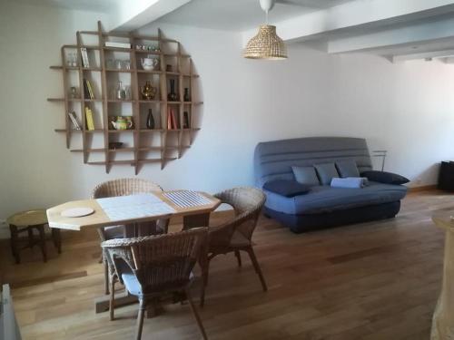 ein Wohnzimmer mit Tisch und Couch in der Unterkunft appartement avec cachet au coeur de Vals les bains in Vals-les-Bains