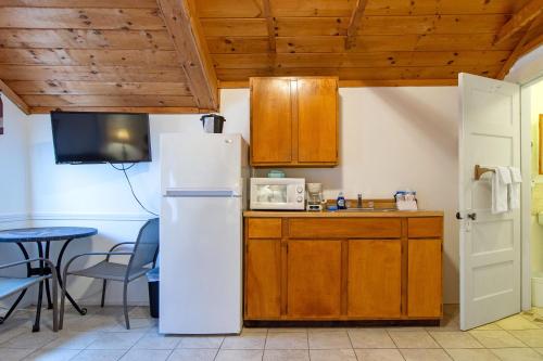 a kitchen with a white refrigerator and a table at Half Moon Motel & Cottages in Weirs Beach