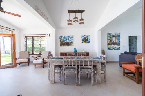 ein Esszimmer mit einem Tisch und Stühlen in der Unterkunft Oasys House - Beautiful Private Beach Front Home in Msambweni